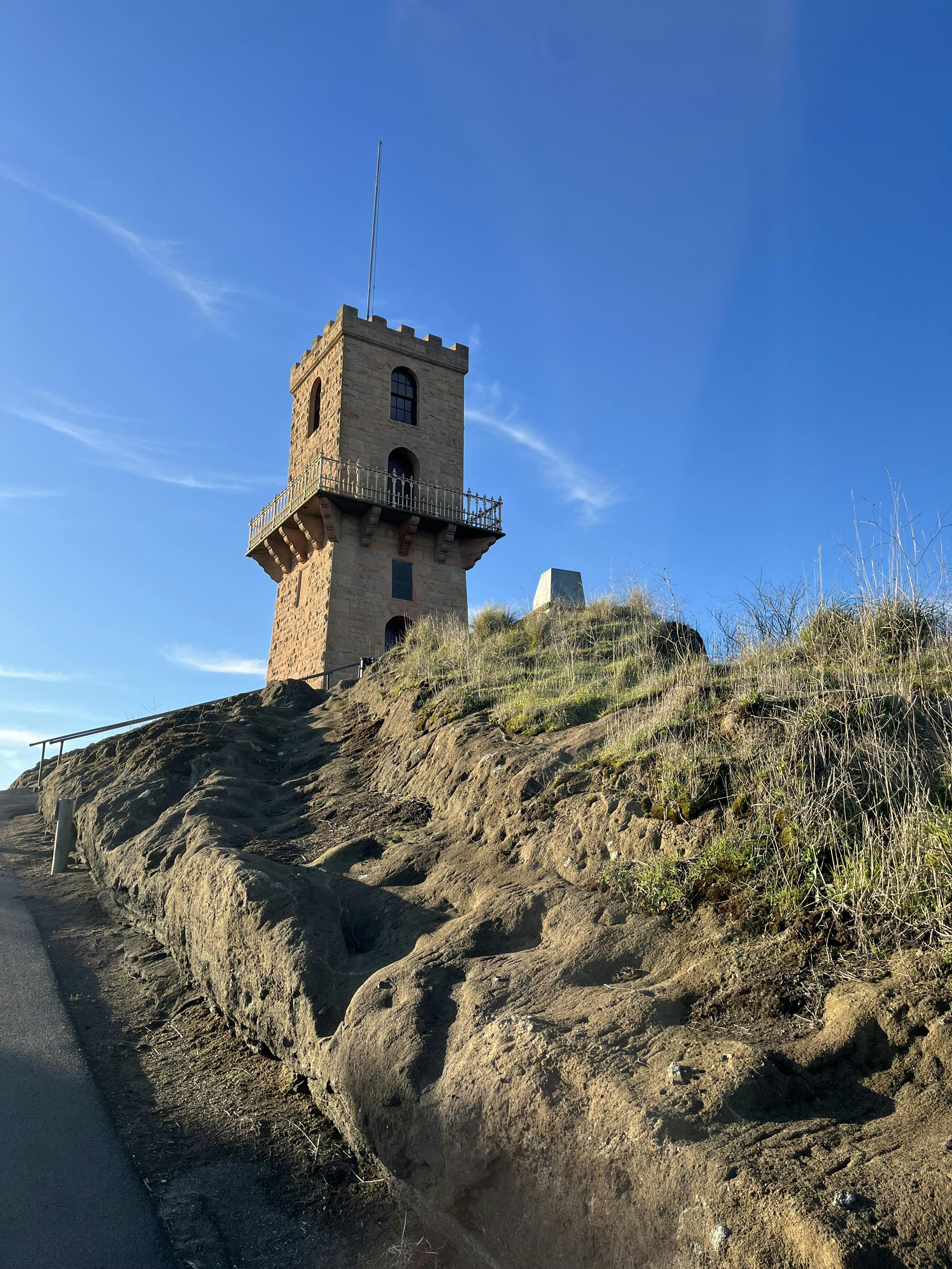 A road leads up to a square stone castle-like tower