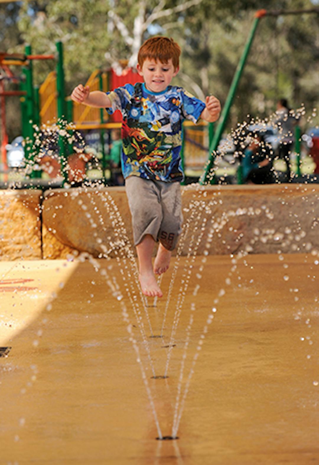 Public Open Space Reinvestment Project Young boy running through a water fountain