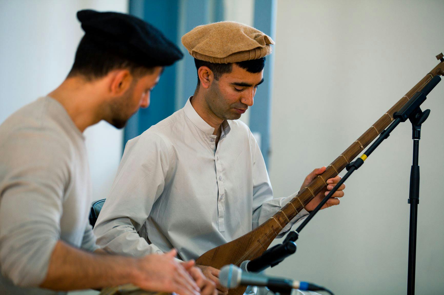 Man (Ilyas Hussain) playing a type of sitar and accompanied by another man playing the drum. Moonah Taste of the World Launch - Multicultural Hub 2021