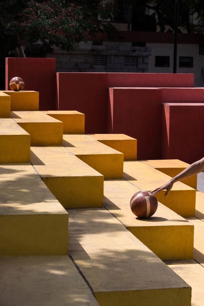 Colourful walling / seating steps surrounding a multipurpose court 