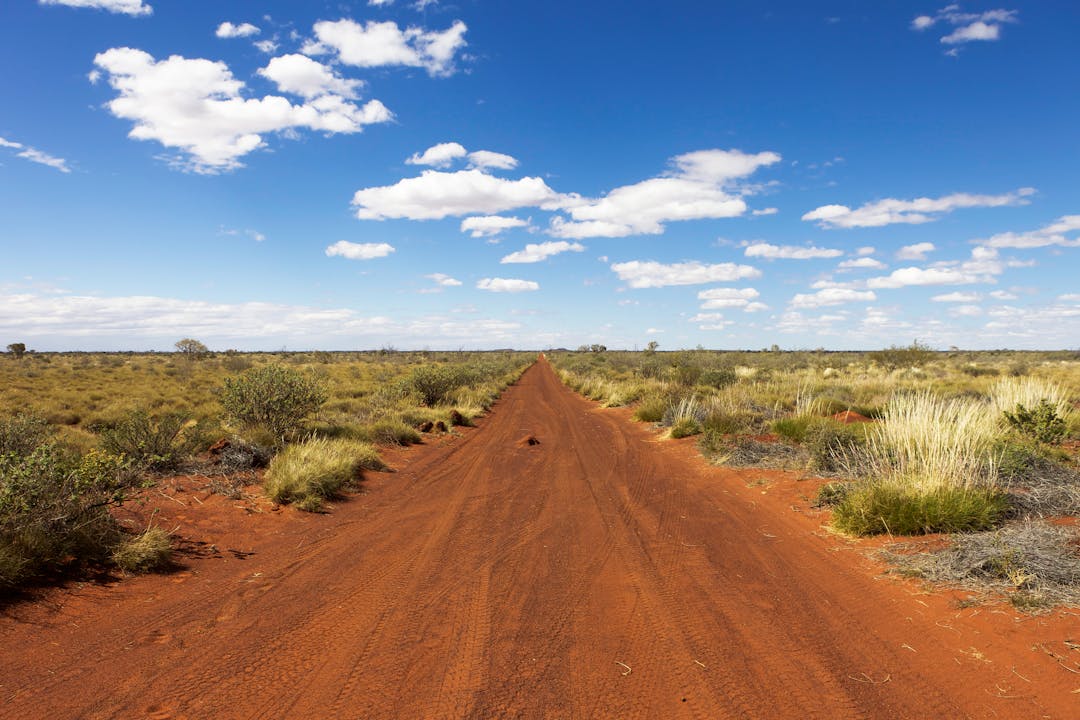 Photograph of unsealed section of the Gunbarrel Highway, Western Australia, surrounded by spinifex grass