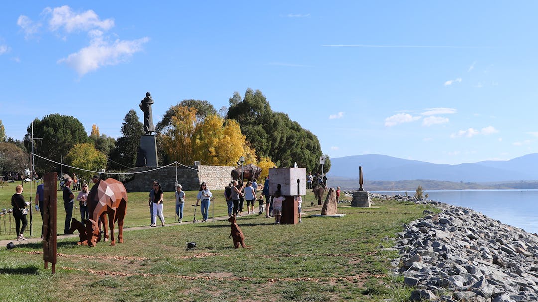 Photograph of attendees by the Lake Jindabyne foreshore on a sunny day enjoying the installations at Lake Light Sculpture