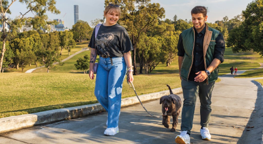 couple walking their dog along a pathway