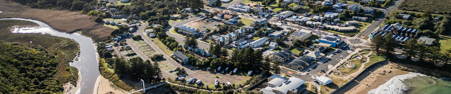 Aerial view of Port Campbell showing the river, bushland, the township grid of streets and buildings, and the beach