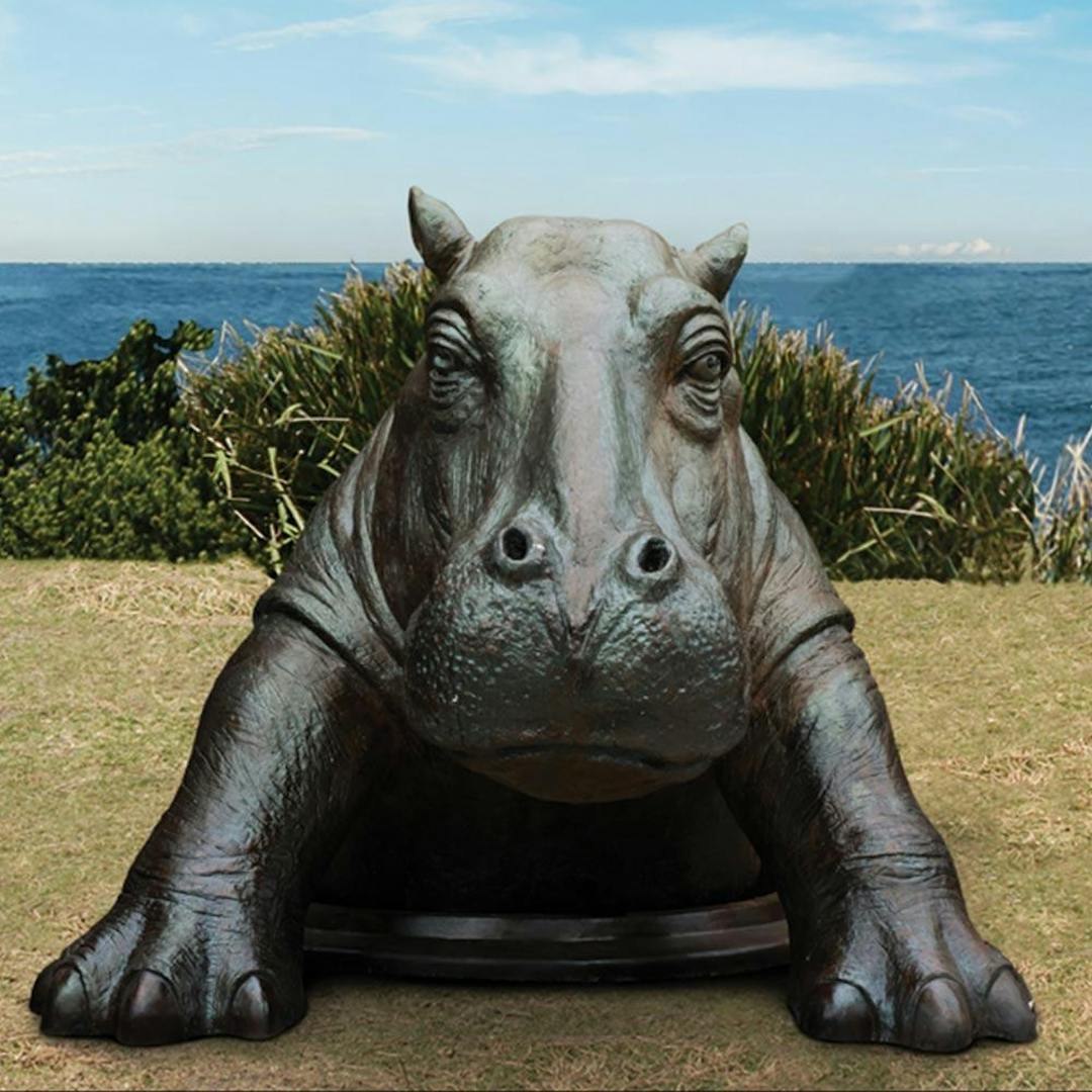 Bronze Sculpture of a Hippo coming out a man-hole in the ground.