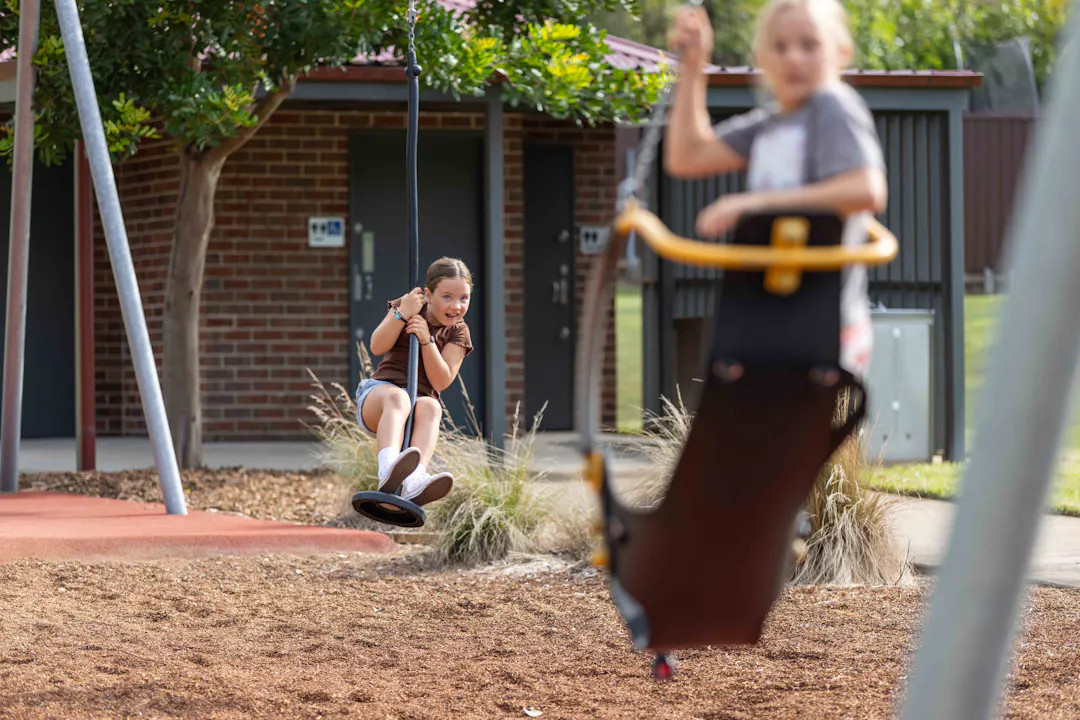 Two girls using a flying fox in a park