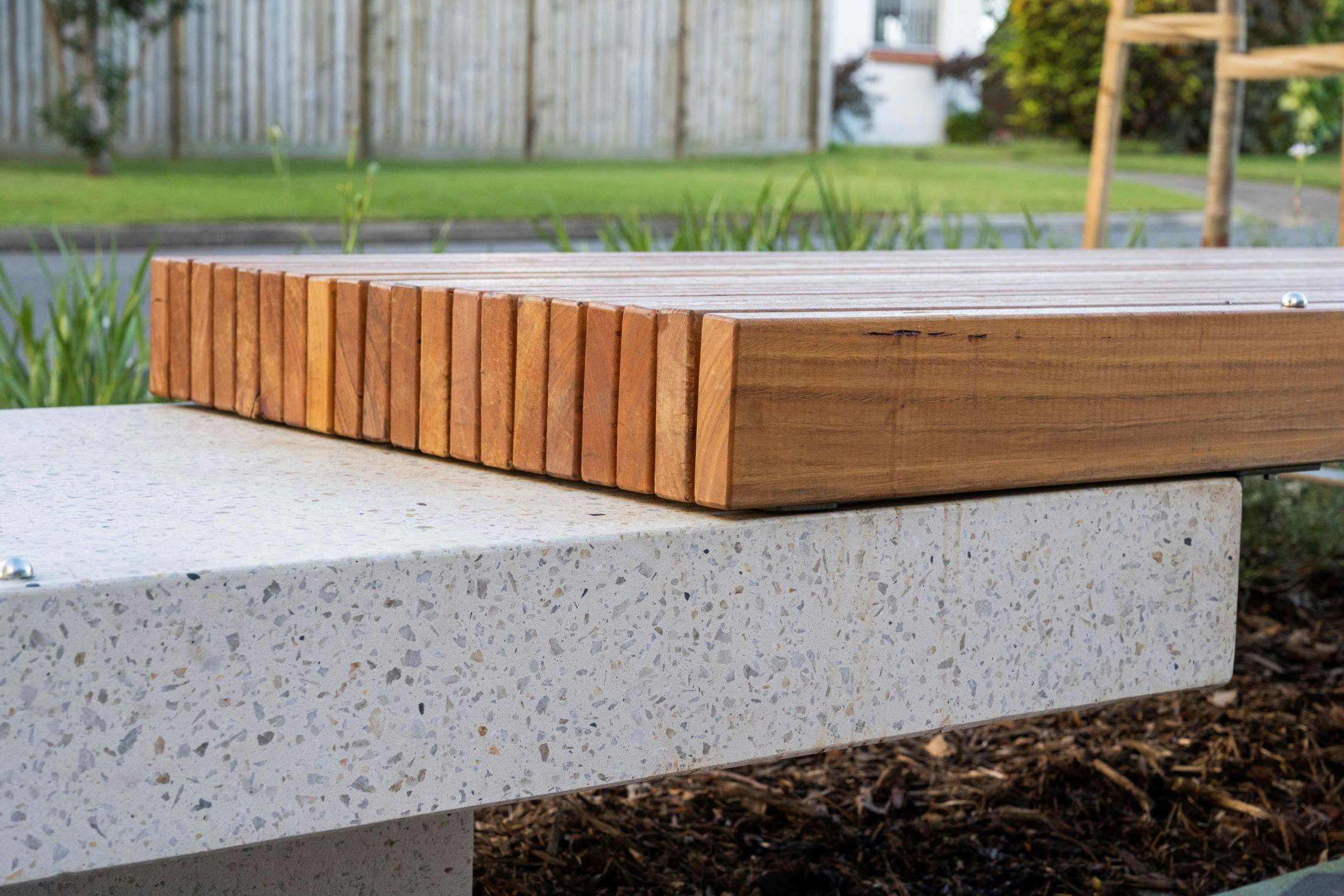 Side view close up of custom platform seating highlighting the timber slat and honed aggregate concrete finish.  