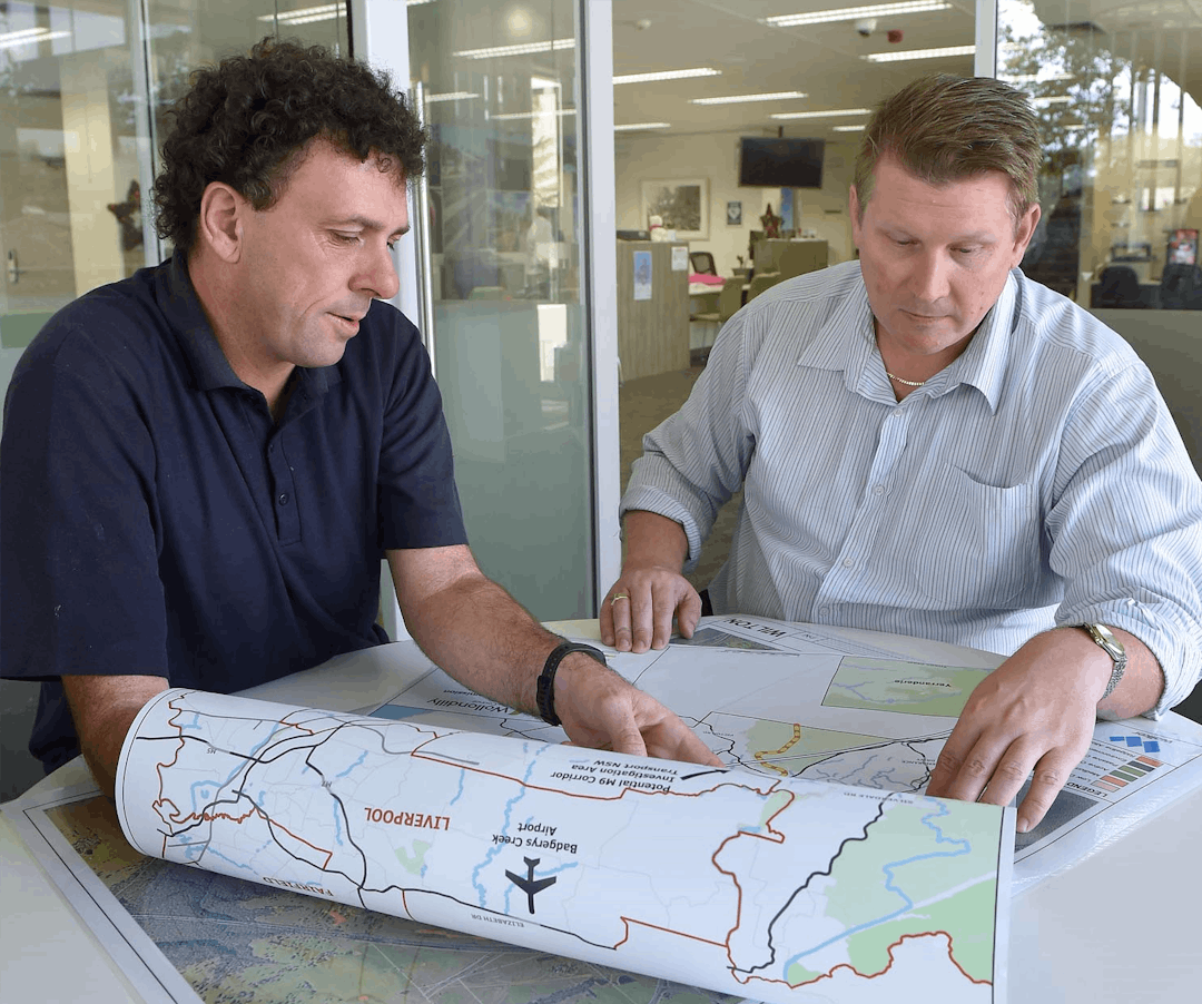Two men at a table looking at maps of Wollondilly Shire
