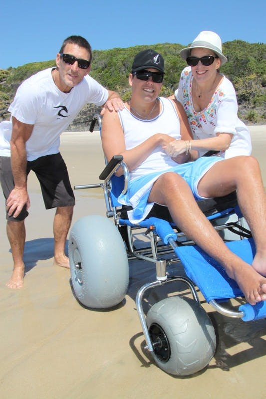 Cabarita Beach resident Sam Ford and his parents, Michael and Margaret, with the new beach wheelchair provided by Council and the Cabarita Beach Surf Lifesaving Club.