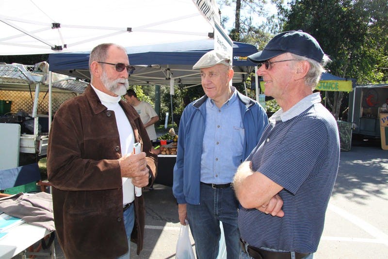The Deputy Mayor of Tweed, Councillor Barry Longland (right), talks to some of the visitors to Council's community information stall at the Uki Markets.
