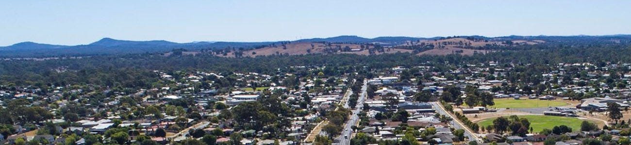 An aerial shot of Anzac Avenue with houses and mountains