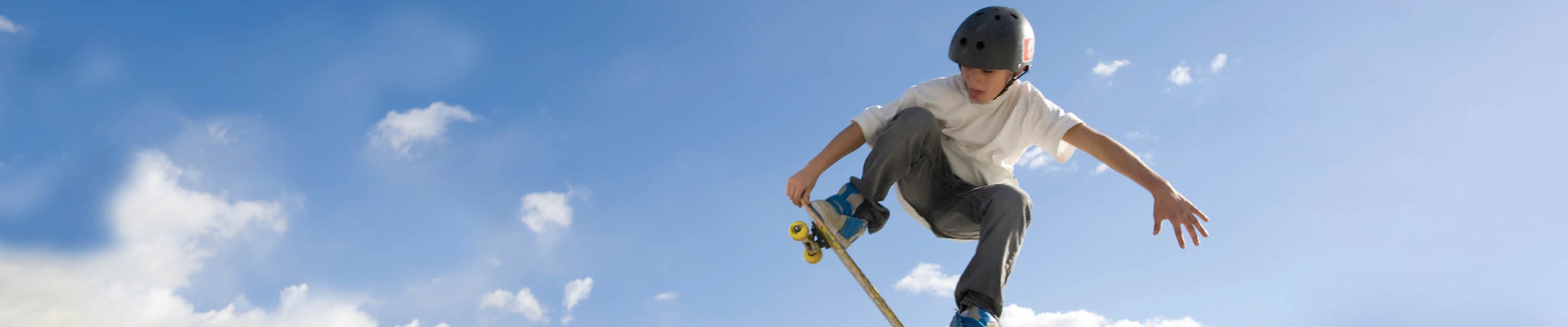 A young skateboarder practices maneuvers at a skatepark 
