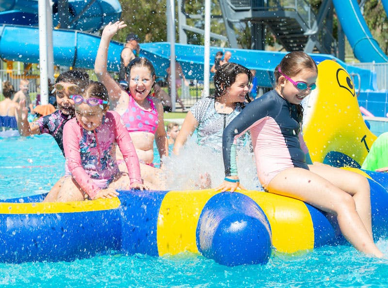 Children playing on inflatable equipment in a pool at Waterworld, Ridgehaven
