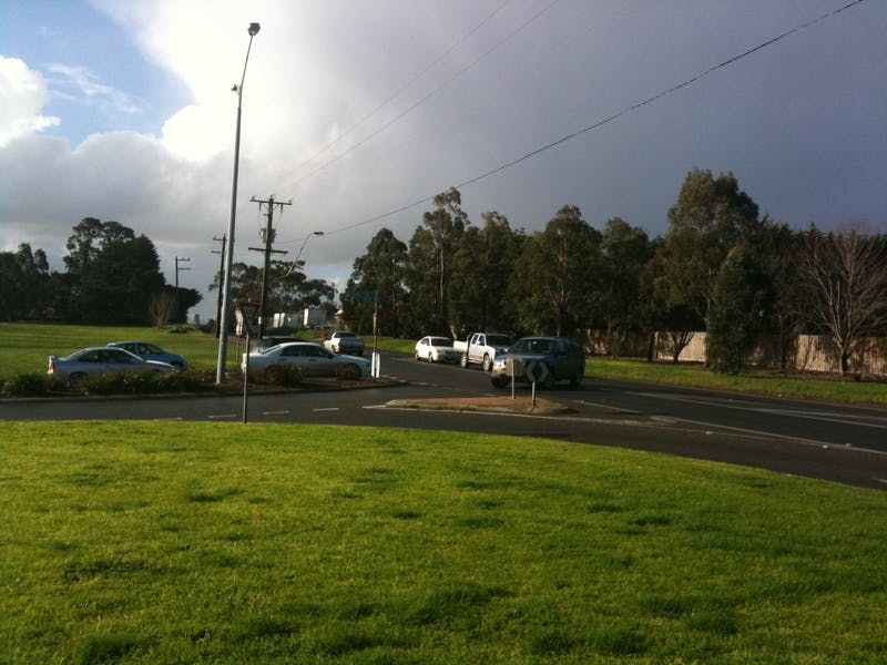 Commuters wait at the intersection of Narre Warren-Cranbourne Road and Baringa Park Drive